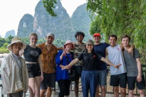 A group poses together in front of karst peaks