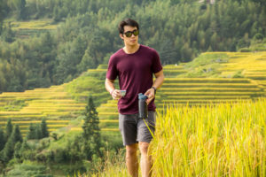 A man walks along a path through ripening rice terraces