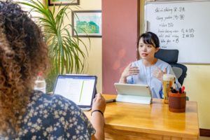 A teacher explains with a tablet and whiteboard during a one-on-one lesson