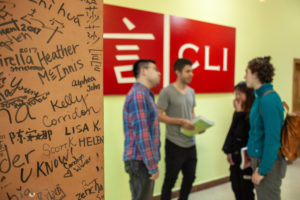 People talk in the CLI Center hallway beside the red CLI sign