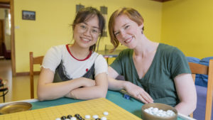Two women smile at the camera from a Go board