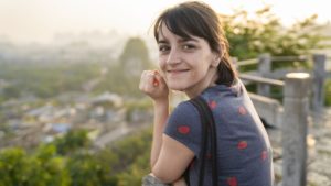 A smiling woman looks back from a hilltop overlook above Guilin