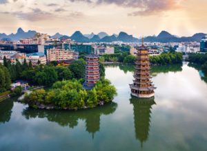 Aerial view of the twin pagodas reflected in a lake with karst peaks