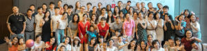 A large crowd of people poses together for a wide group photo