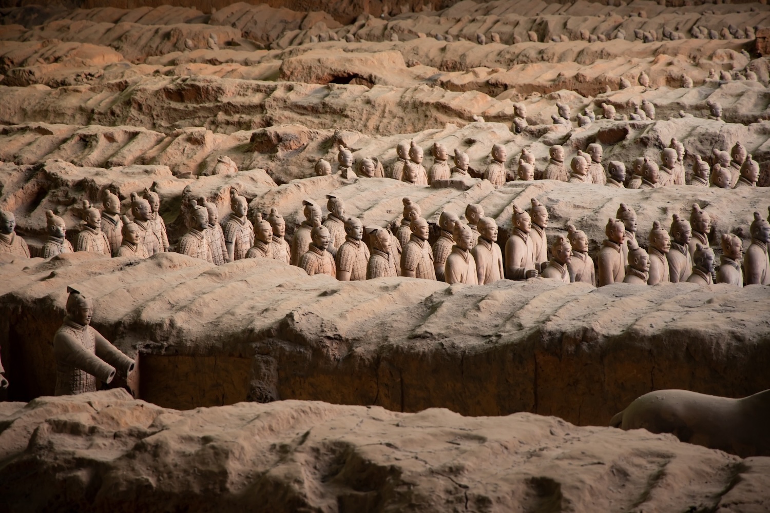 terracotta soldiers in rows at the main exhibition hall in xi'an, china