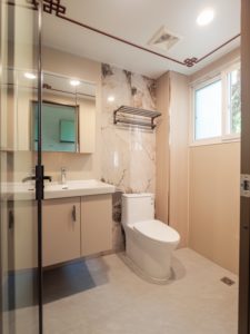 A modern bathroom with a glass shower, sink and toilet