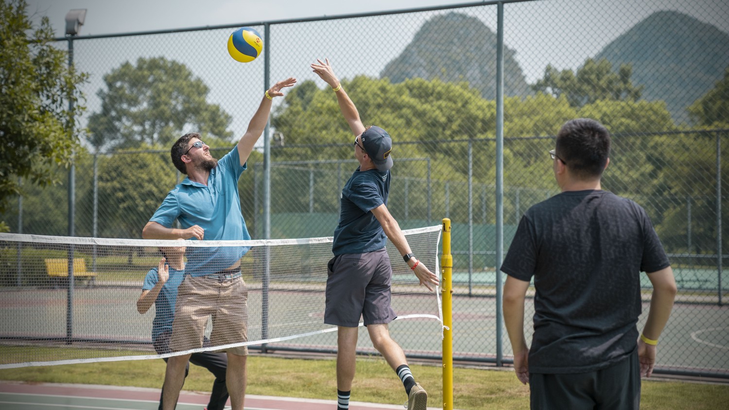 An outdoor volleyball game with CLI students and teachers